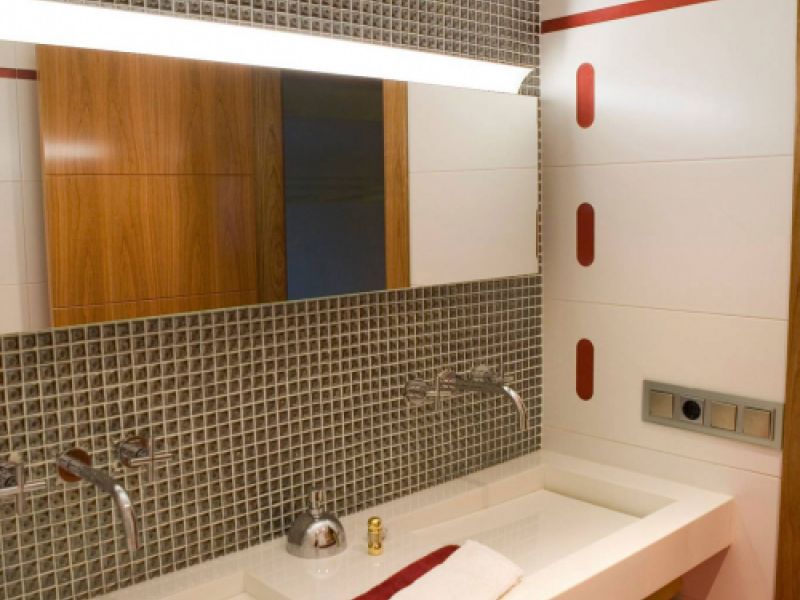 Baño con lavabos grandes rectangulares de color blanco y pared con detalles en color rojo