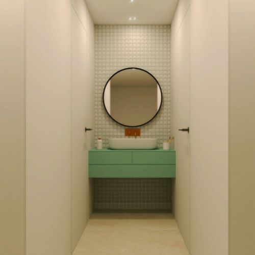 Baño con espejo circular y mueble en color verde agua